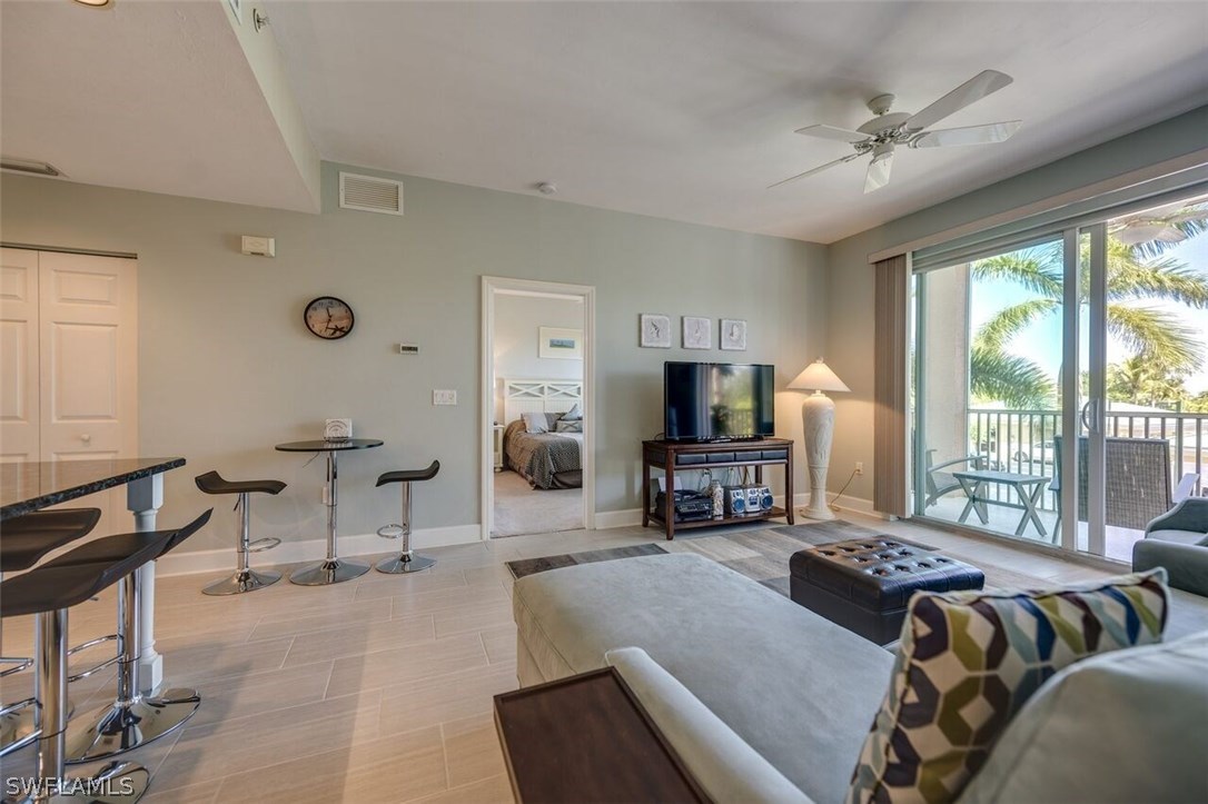2060 Matecumbe Key Road, Unit 2207 Punta Gorda, FL 33955 - Photo 7 of 21 a living room with furniture a flat screen tv and a large window