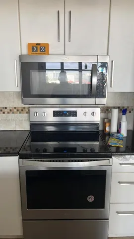 a stove top oven sitting inside of a kitchen