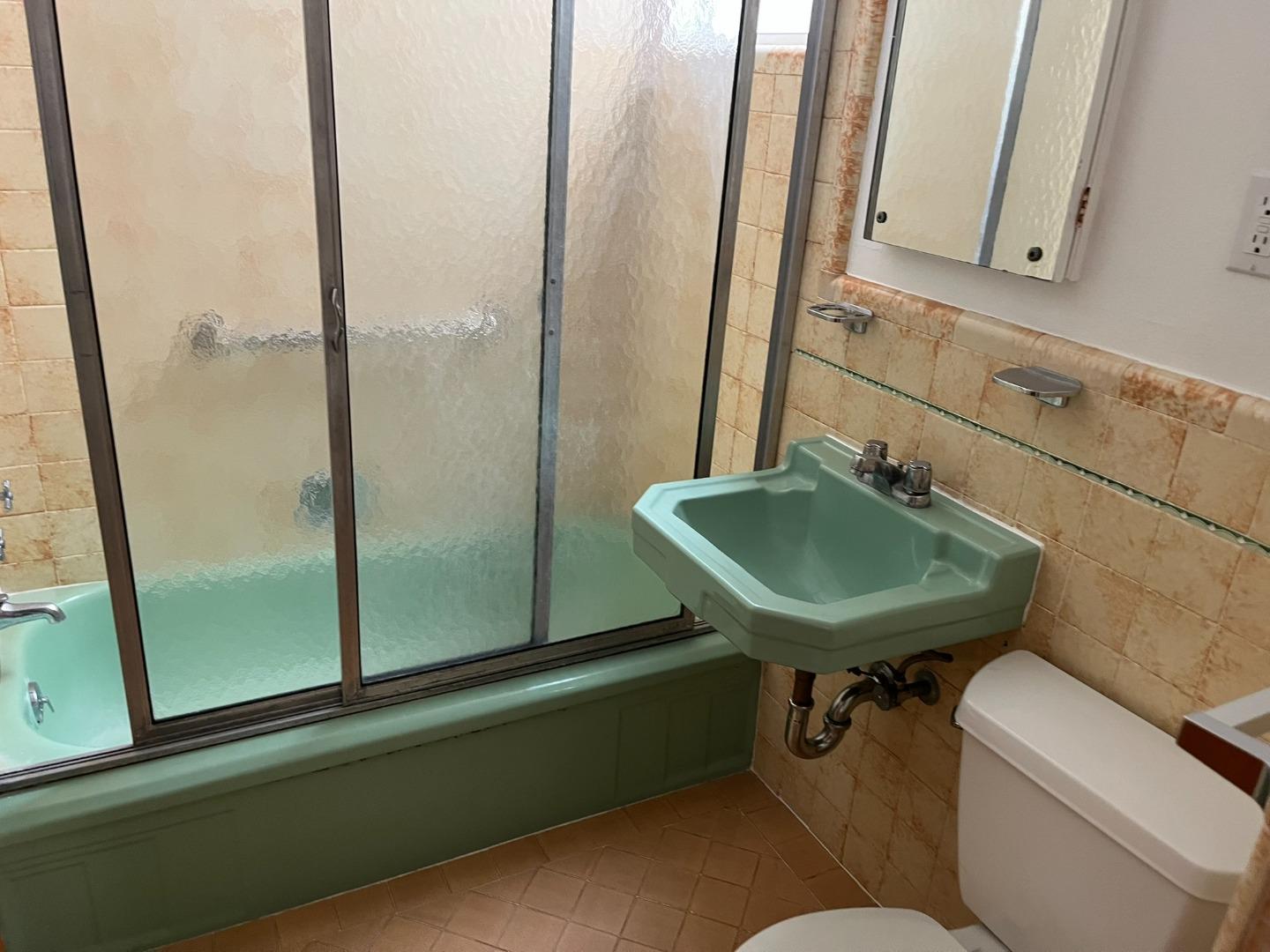 2028-2030 Taraval Street San Francisco, CA 94116 - Photo 16 of 18 a bathroom with a sink a toilet and a mirror
