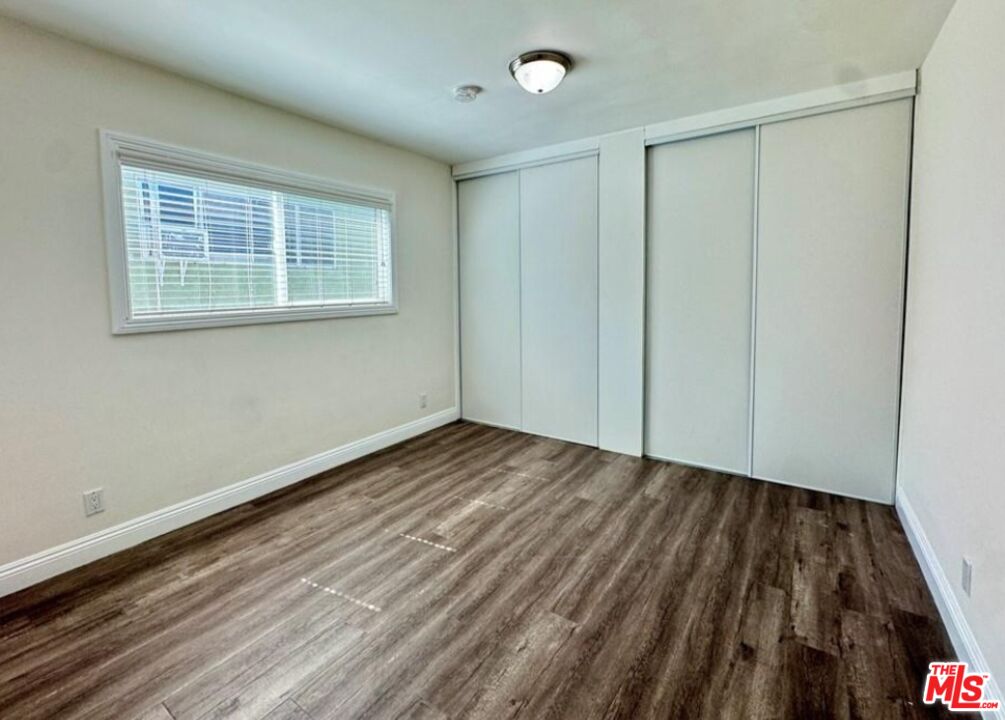 2040 South Sherbourne Drive, Unit 4 Los Angeles, CA 90034 - Photo 4 of 14 a view of an empty room with wooden floor and a window