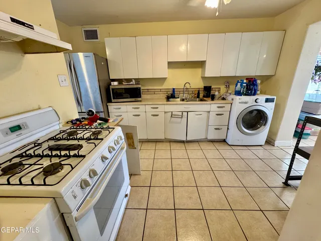 a kitchen with a stove a sink and a refrigerator