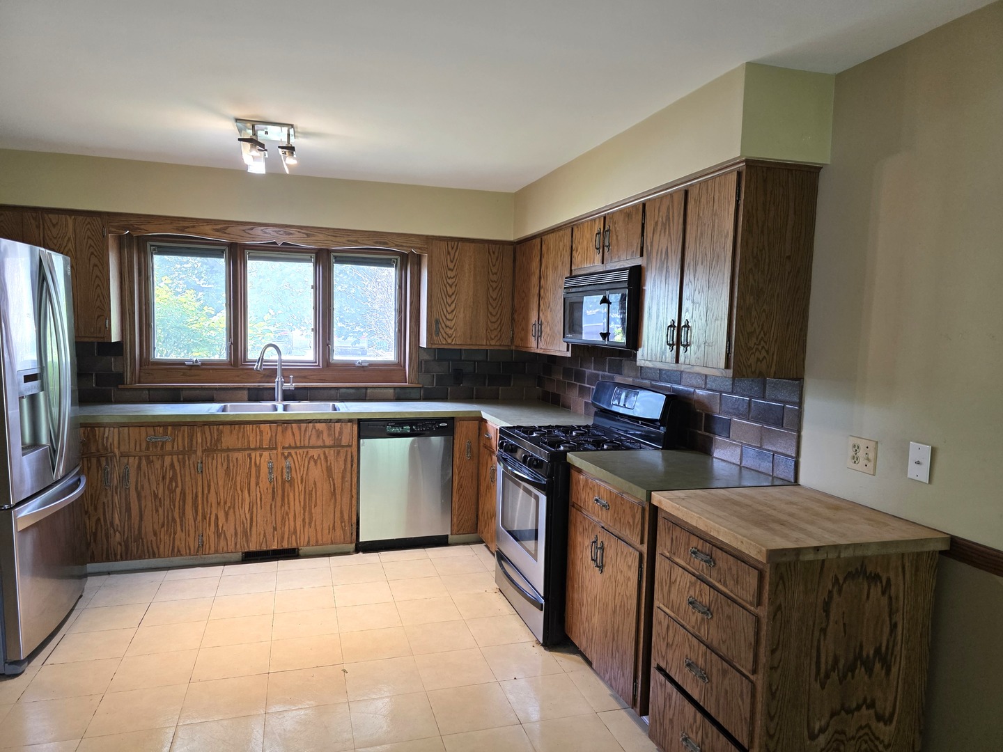 1546 Wheeler Street Woodstock, IL 60098 - Photo 12 of 32 a kitchen with stainless steel appliances granite countertop a stove a sink and a microwave