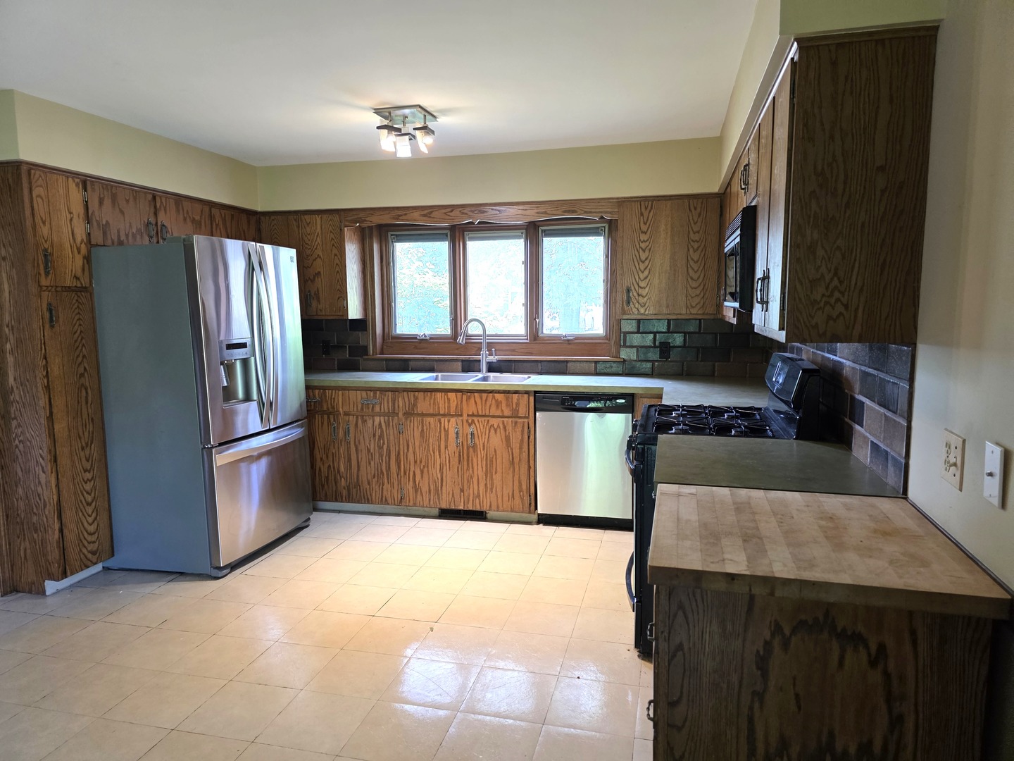 1546 Wheeler Street Woodstock, IL 60098 - Photo 13 of 32 a kitchen with stainless steel appliances granite countertop a sink stove and refrigerator