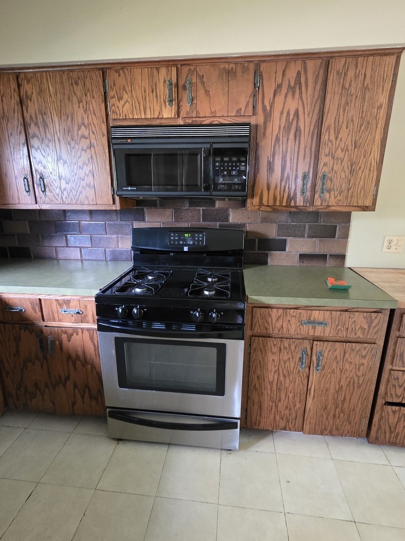 1546 Wheeler Street Woodstock, IL 60098 - Photo 15 of 32 a kitchen with stainless steel appliances granite countertop a stove and a microwave