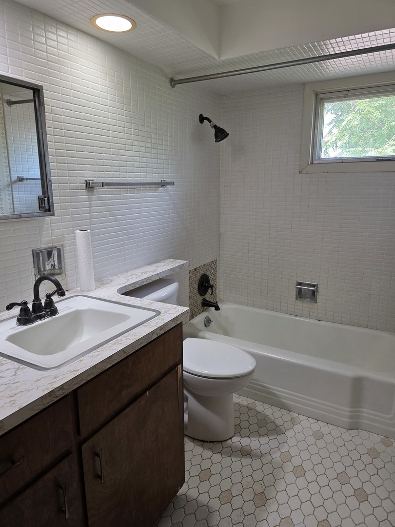 1546 Wheeler Street Woodstock, IL 60098 - Photo 25 of 32 a bathroom with a sink a toilet and shower
