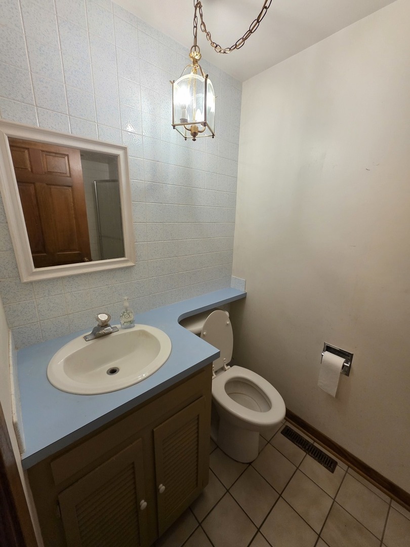 1546 Wheeler Street Woodstock, IL 60098 - Photo 26 of 32 a bathroom with a toilet a sink and mirror