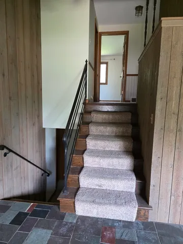 a view of staircase with wooden floor and fan