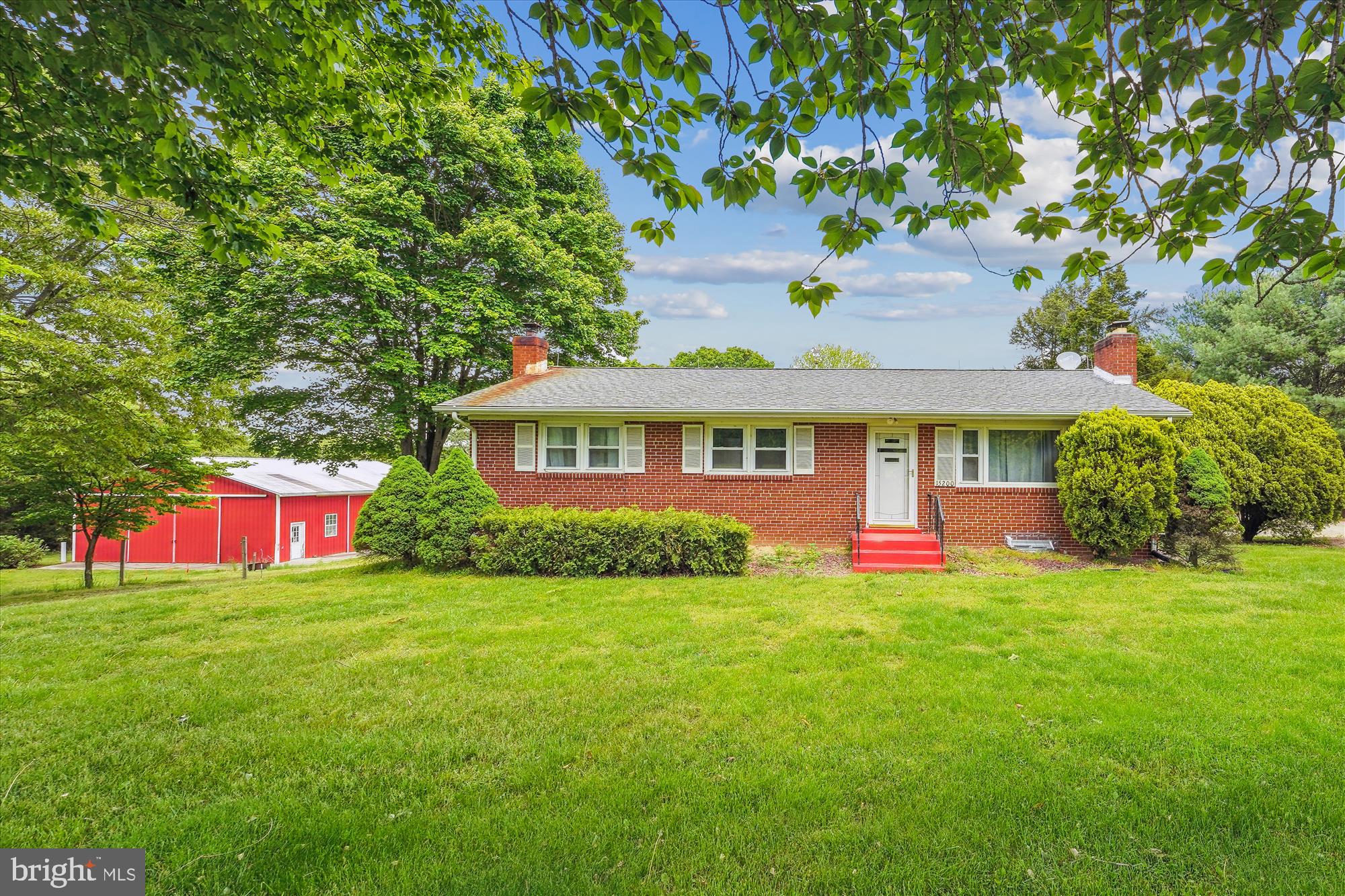 a front view of a house with yard and green space