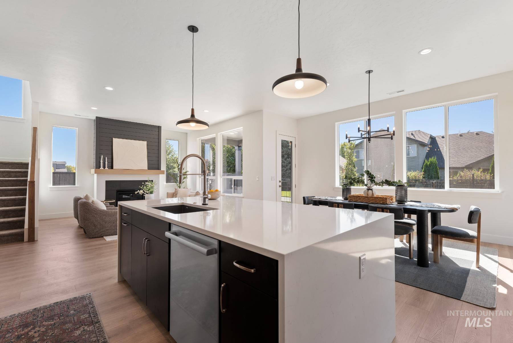 1319 West Malbar Street Meridian, ID 83646 - Photo 12 of 31 Kitchen featuring dark cabinetry, pendant lighting, light wood finished floors, stainless steel dishwasher, and recessed lighting