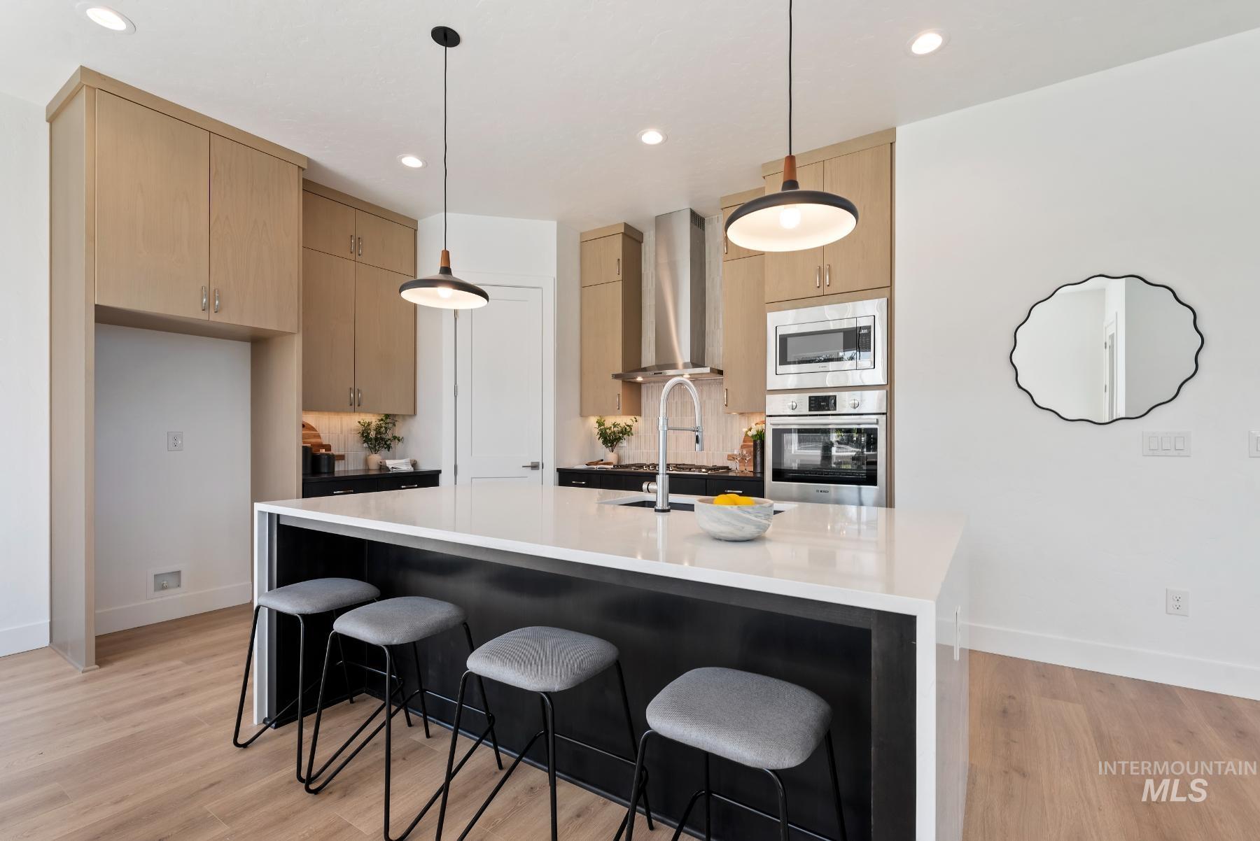 1319 West Malbar Street Meridian, ID 83646 - Photo 13 of 31 Kitchen with a breakfast bar, pendant lighting, recessed lighting, stainless steel appliances, and light wood-style flooring