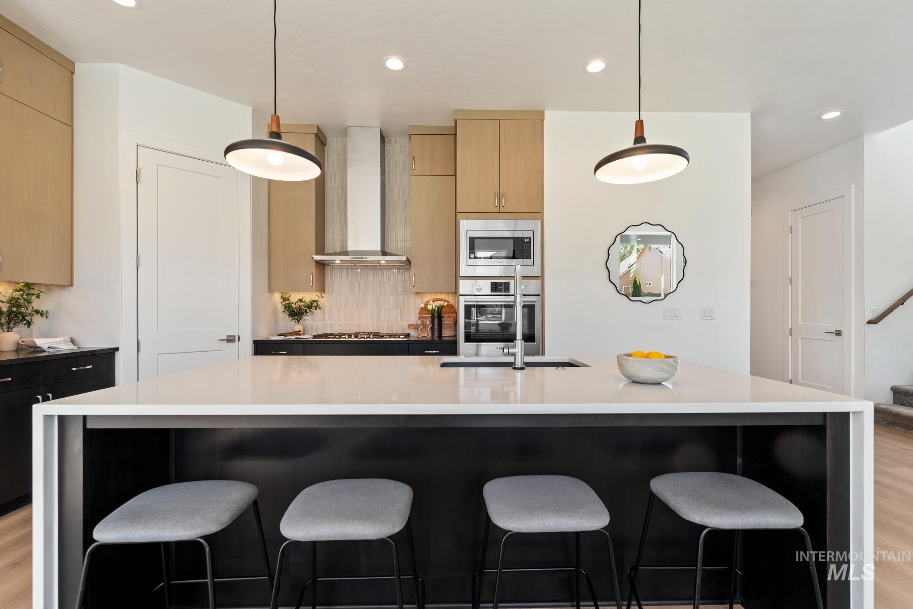 1319 West Malbar Street Meridian, ID 83646 - Photo 14 of 31 Kitchen featuring light wood-style floors, recessed lighting, backsplash, hanging light fixtures, and dark stone countertops
