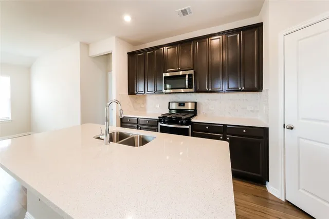 a kitchen with stainless steel appliances a microwave sink and cabinets