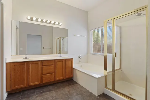 a bathroom with a tub a sink and a large mirror