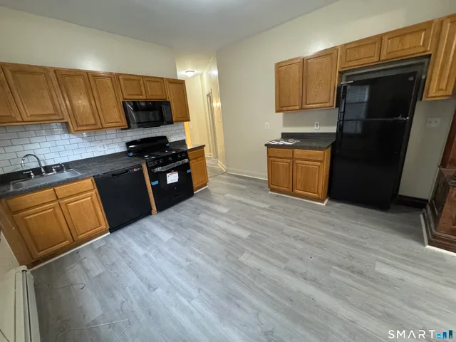a kitchen with granite countertop a refrigerator stove and microwave