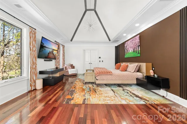 a bedroom with a bed wooden floor and window