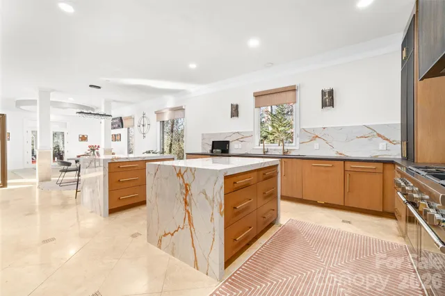 a kitchen with stainless steel appliances kitchen island granite countertop a sink and a refrigerator