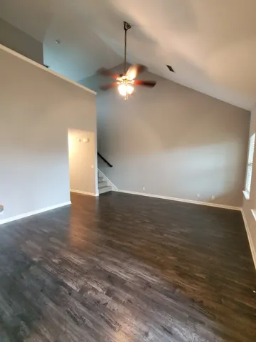 a view of a room with wooden floor and ceiling fan