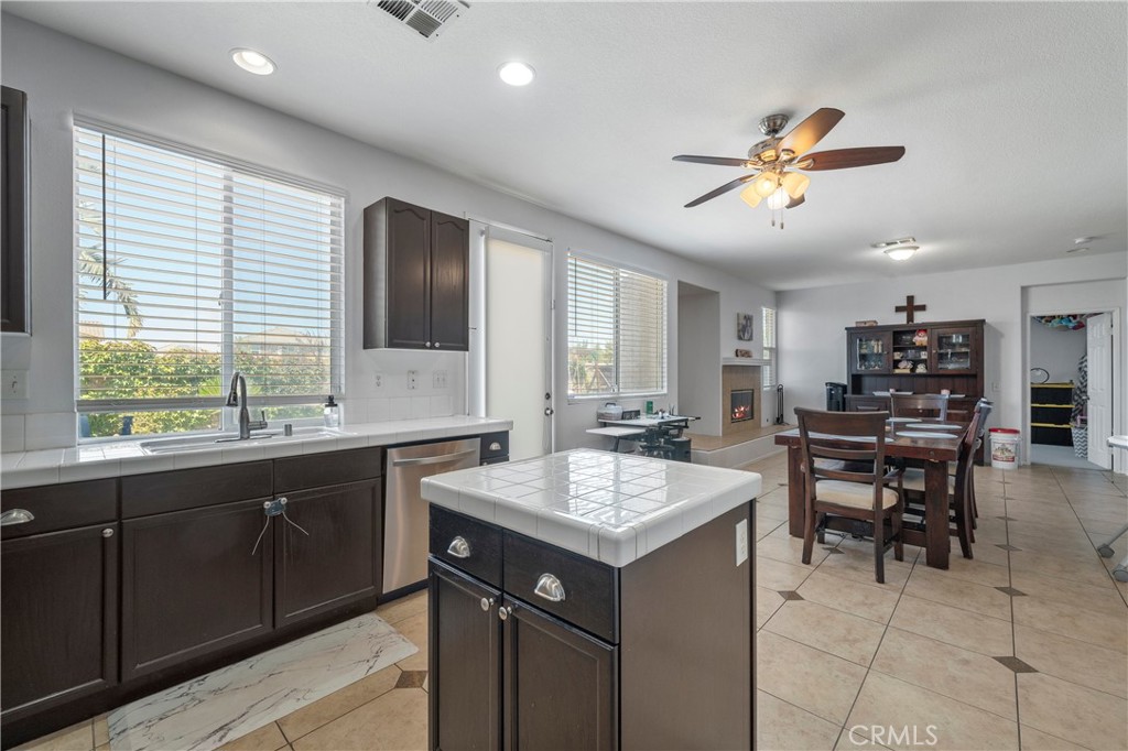7441 Clementine Drive Eastvale, CA 92880 - Photo 13 of 39 a kitchen with a stove a sink a dining table and chairs