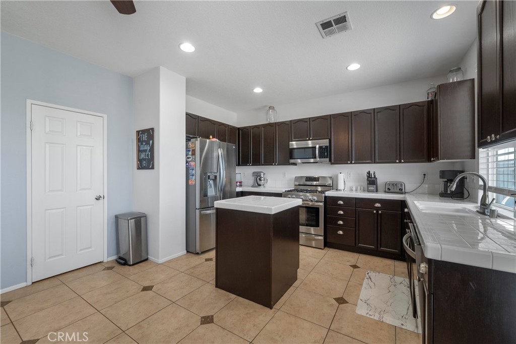 7441 Clementine Drive Eastvale, CA 92880 - Photo 15 of 39 a kitchen with stainless steel appliances granite countertop a refrigerator stove and sink