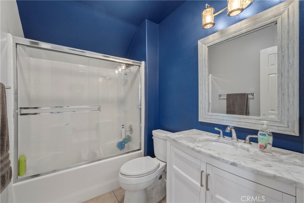 7441 Clementine Drive Eastvale, CA 92880 - Photo 22 of 39 a bathroom with a granite countertop sink toilet and shower