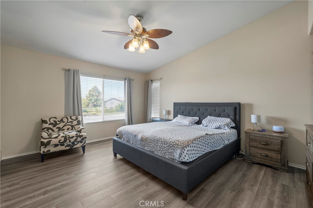 7441 Clementine Drive Eastvale, CA 92880 - Photo 26 of 39 a bedroom with a bed and a chandelier