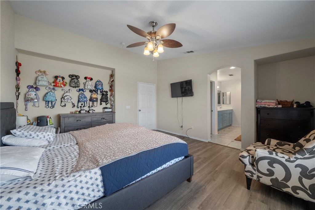 7441 Clementine Drive Eastvale, CA 92880 - Photo 29 of 39 a bedroom with a bed and a chandelier