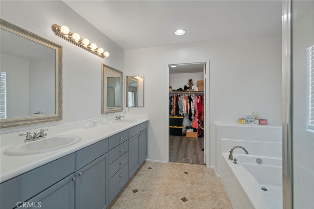 7441 Clementine Drive Eastvale, CA 92880 - Photo 30 of 39 a spacious bathroom with a tub sink and mirror