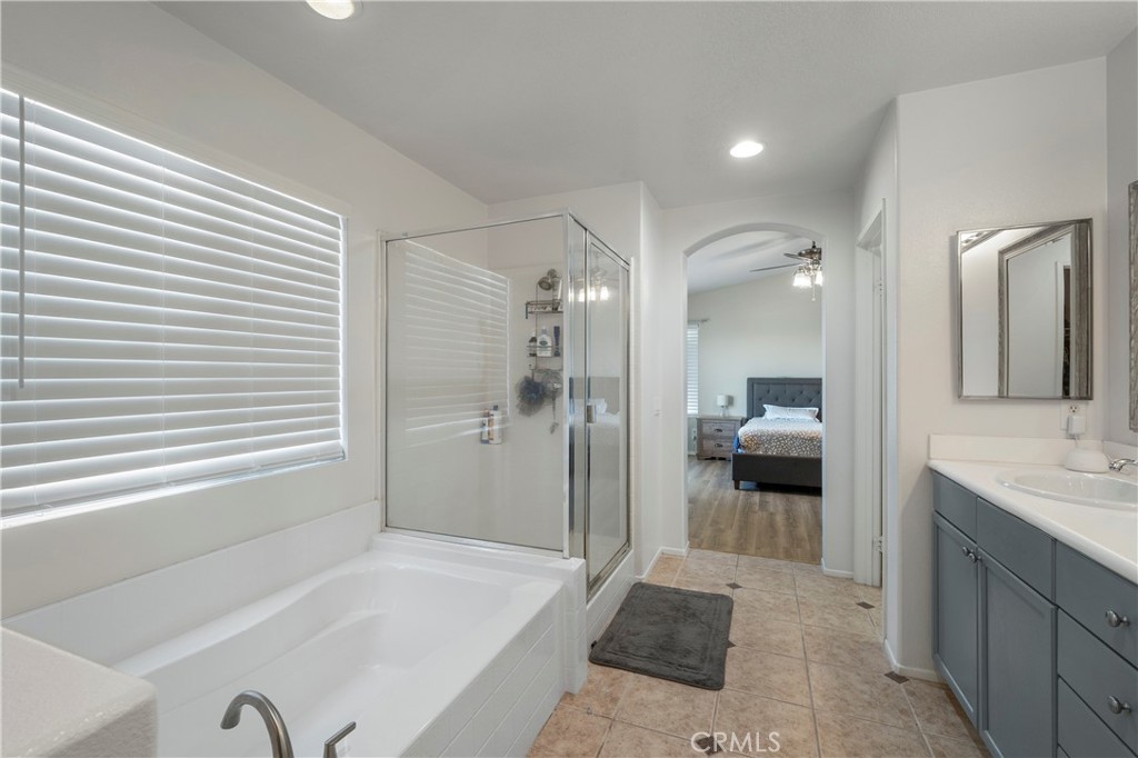 7441 Clementine Drive Eastvale, CA 92880 - Photo 31 of 39 a bathroom with a tub sink shower and a mirror