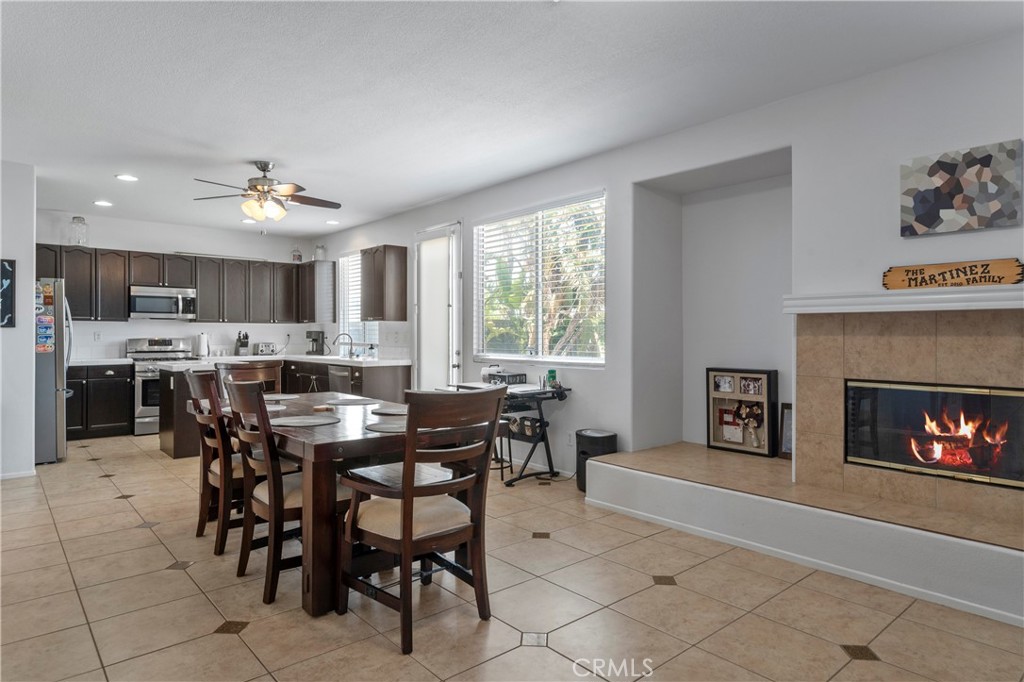 7441 Clementine Drive Eastvale, CA 92880 - Photo 7 of 39 a view of a dining room with furniture and a fireplace