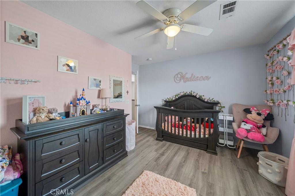 7441 Clementine Drive Eastvale, CA 92880 - Photo 10 of 39 a bedroom with a bed and a chandelier