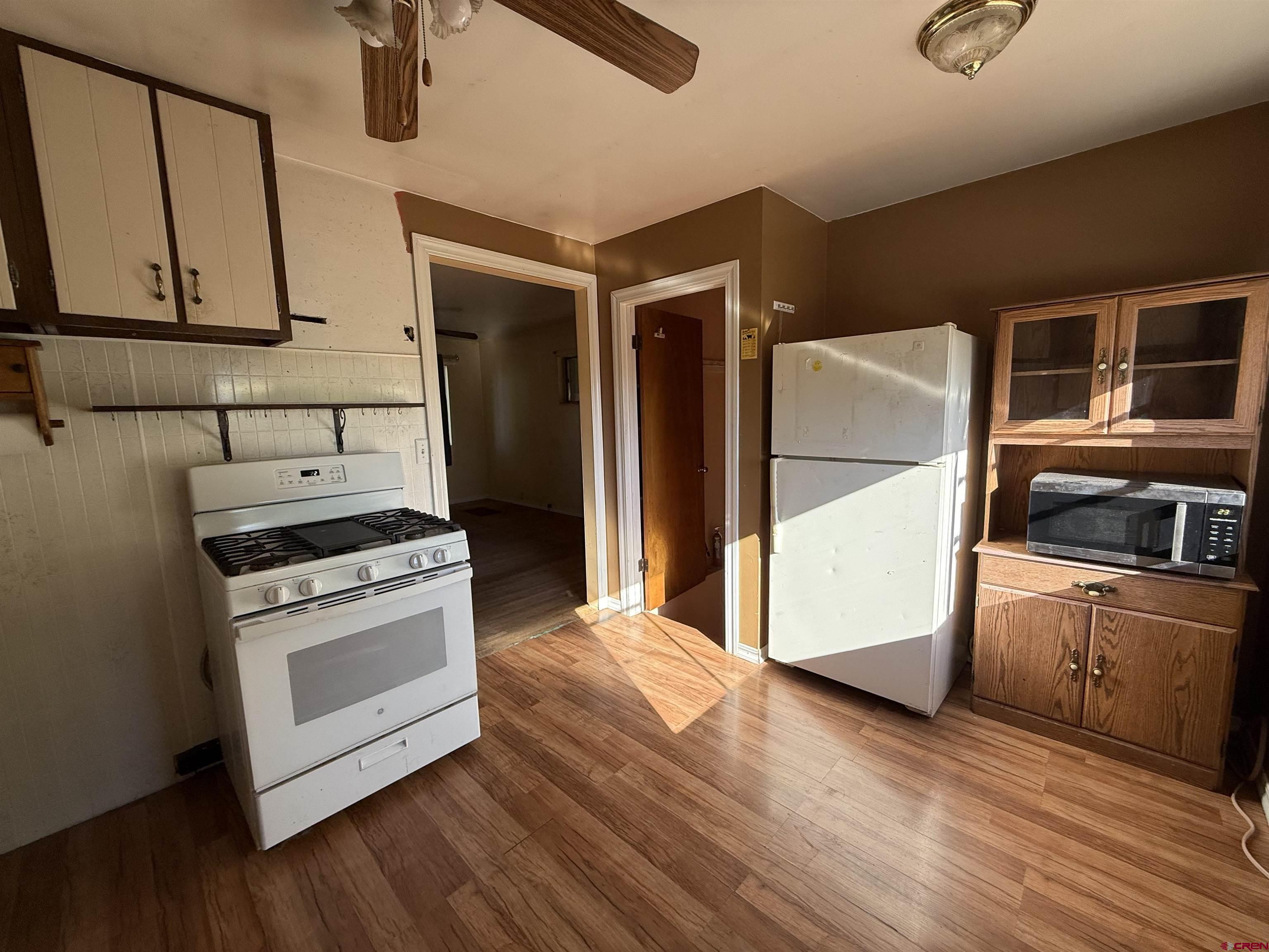 418 South Valley Road Cortez, CO 81321 - Photo 5 of 32 a kitchen with a stove cabinets and wooden floor