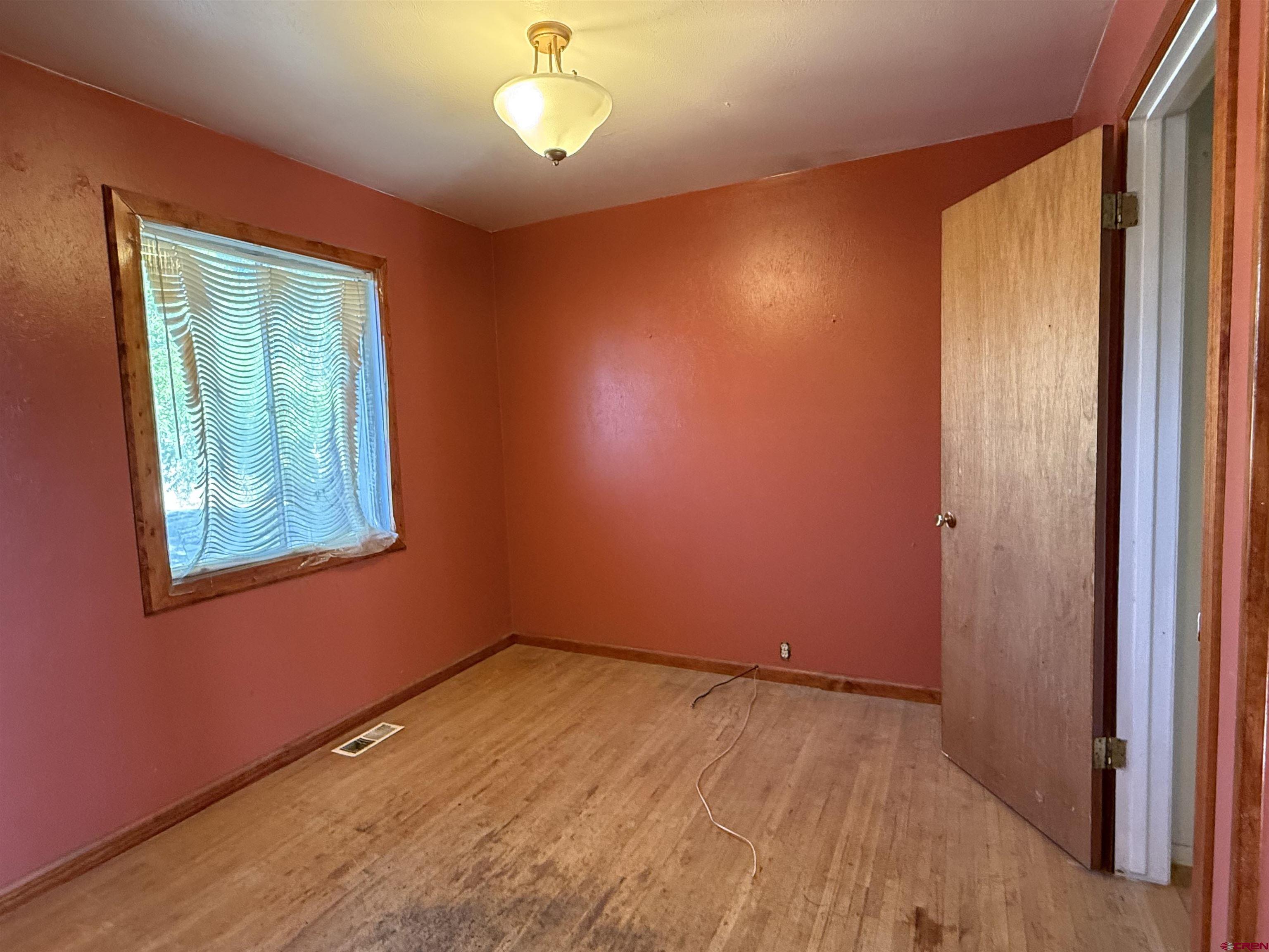 418 South Valley Road Cortez, CO 81321 - Photo 10 of 32 an empty room with wooden floor and windows
