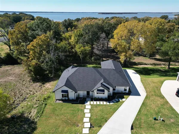 an aerial view of a house with swimming pool and green space