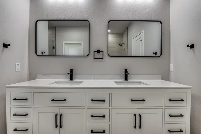 a bathroom with double vanity sinks and a mirror