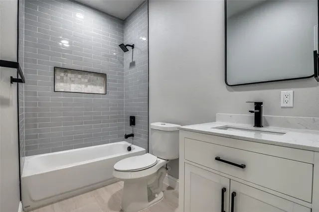 a bathroom with a toilet a sink a mirror and bathtub