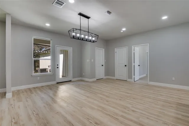 a view of an empty room with wooden floor