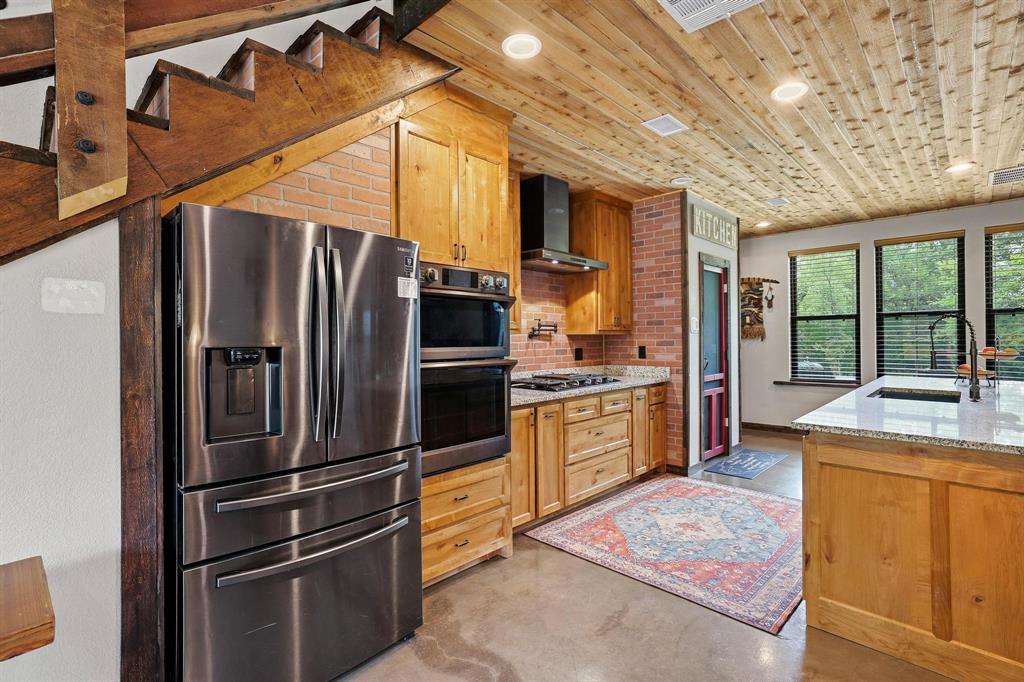 1900 County Road 1535 Bonham, TX 75418 - Photo 16 of 37 a kitchen with stainless steel appliances granite countertop a refrigerator a stove and a sink with large countertops