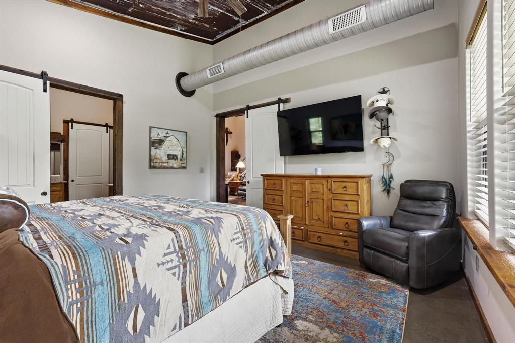 1900 County Road 1535 Bonham, TX 75418 - Photo 18 of 37 a bedroom with a bed a couch and a flat screen tv