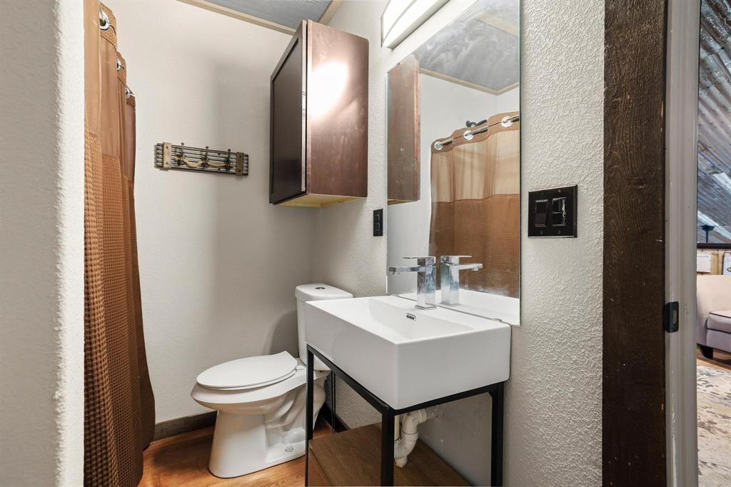 1900 County Road 1535 Bonham, TX 75418 - Photo 31 of 37 a bathroom with a toilet a sink and mirror