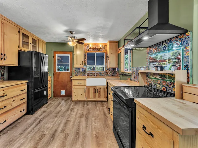 a open kitchen with stainless steel appliances granite countertop a lot of counter space and wooden floor