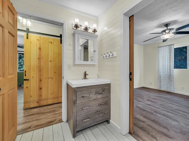 a spacious bathroom with a granite countertop sink a toilet and a mirror