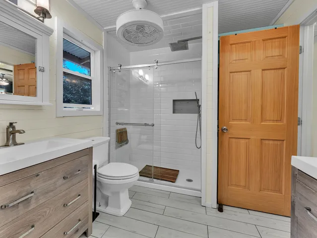 a bathroom with a sink vanity toilet and shower