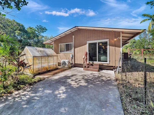 a view of a house with backyard and sitting area