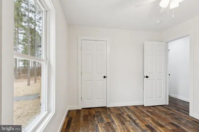 a view of hallway with closet and wooden floor
