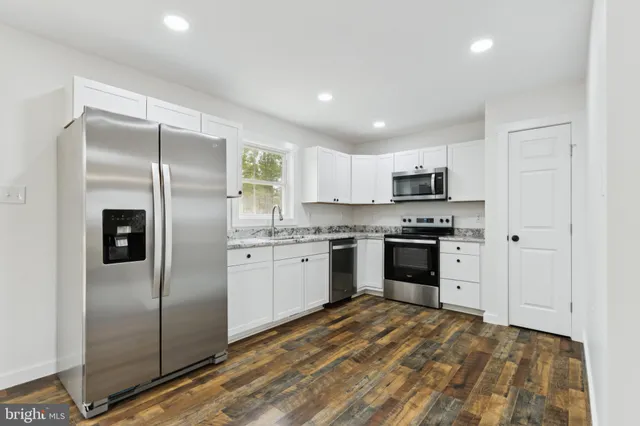 a kitchen with a refrigerator a sink and cabinets