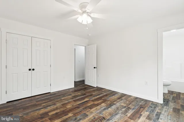 a view of a room with wooden floor and a ceiling fan