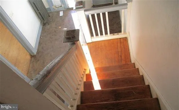 a view of staircase with wooden floor and railing