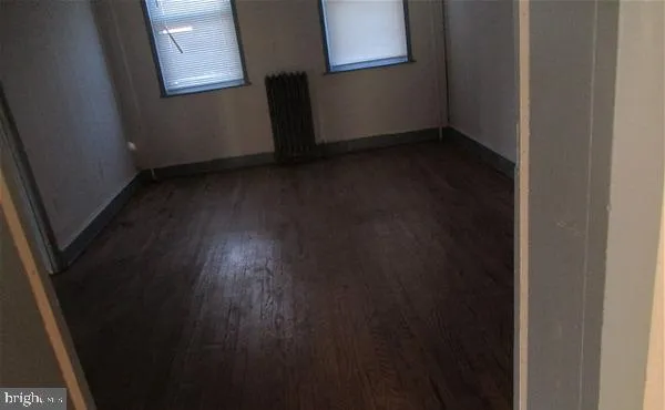 a view of a room with wooden floor and a window