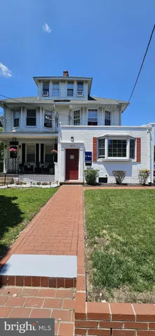 a front view of a building with a garden and plants