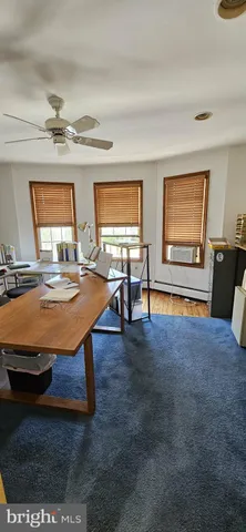 a view of a workspace with furniture and a window